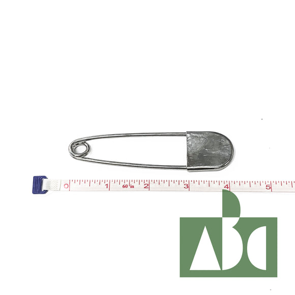 A large metal net pin. The pin is lined up against a piece of measuring tape to reference its 4 1/2 inch length.