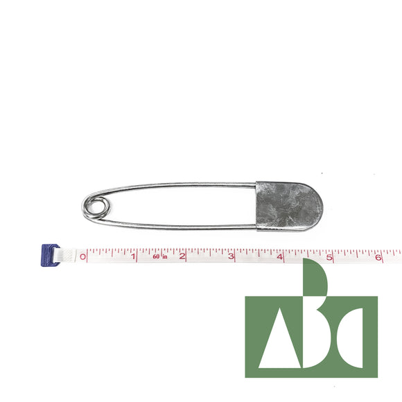 A large metal net pin. The pin is lined up against a piece of measuring tape to reference its 5 inch length.